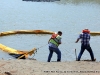 TMS Contracting employees pulling the turbidity barrier closer to shore.