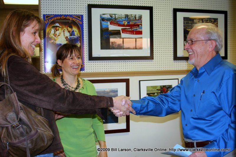 Artist Jim Hancock is introduced to a friend of Bakery owner Silke Tyler. In the background is his piece Three wooden boats photographed in Anjaccio, Corsica Artist Jim Hancock is introduced to a friend of Bakery owner Silke Tyler. In the background is his piece Three wooden boats photographed in Anjaccio, Corsica