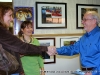 Artist Jim Hancock is introduced to a friend of Bakery owner Silke Tyler. In the background is his piece Three wooden boats photographed in Anjaccio, Corsica