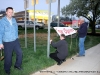 Larson Enterprises owner Eric Larson stands in front of his business as an open sign is hung out by the street