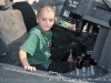 A child sits behind the controls of a helicopter