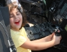 A child sits behind the controls of a helicopter