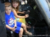 A child sits behind the controls of a helicopter