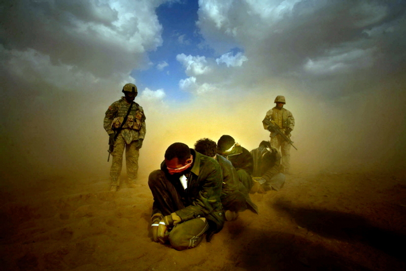 American soldiers guard a group of detainees