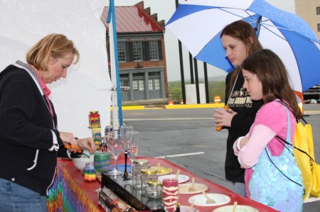 A mother and daughter doesn\'t let the bad weather deter them as they shop at a candle vendor