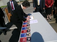 Department of Safety Deputy Commissioner Greta Dajani, surrounded by key safety partners, signs the new Strategic Highway Safety Plan