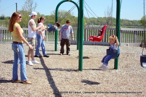 Parents pushing their children on the swings at one of Clarksville TN's may Parks