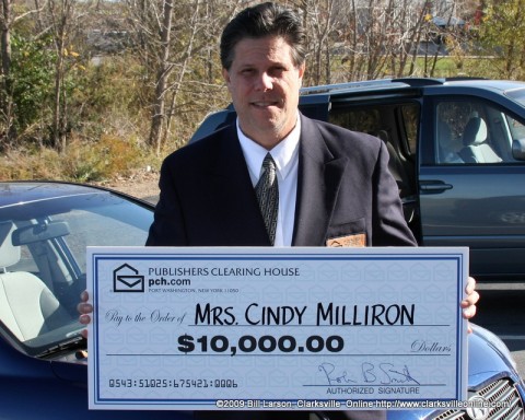 PCH Prize Patrol Deputy Al Guerra holds one of the 101 Reality Checks 