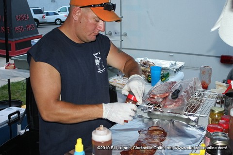 The grill master from the Smokin Swine Team from Clarksville, TN preps some ribs