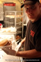 The cook at The Smokin' Rednecks BBQ stand showing off one of their pulled pork sandwichs