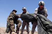 U.S. and Afghan National Army soldiers work together to fold a parachute that was used during a resupply air drop mission at Forward Operating Base Gamberi, July 10th. The air drop consisted of wood to build new buildings, Hesco barriers for base security, water and Halal meals, ANA's version of Meals Ready to Eat.