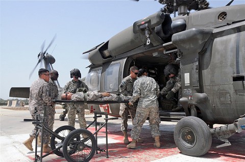 Students in a recent litter-bearer class held at Salerno Hospital get some hands-on training by transferring a “patient” from a rickshaw litter carrying device into an awaiting Blackhawk helicopter.  (Photo by U.S. Sgt. Brent C. Powell, 3rd Brigade, 101st Airborne Division)