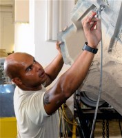 U.S. Army Spc. Luis A. Pagan, from Hoboken, NJ, a wheeled vehicle mechanic, maintenance platoon, Company G, 626th Brigade Support Battalion, 3rd Brigade, 101st Airborne Divison, uses a pair of pliers to remove a cotter pin from the hood support of a humvee in the maintenance shop. (Photo by U.S. Army Sgt. Brent C. Powell, 3rd Brigade, 101st Airborne Division)