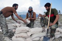 Afghan National Army soldiers stack sandbags to improve their fighting positions at Combat Outpost Thomas above the Marawarah District here July 7th. (Photo by U.S. Army Spc. Albert L. Kelley, 300th Mobile Public Affairs Detachment)