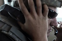 Minutes after his vehicle has been hit by an improvised explosive device, U.S. Army Spc. William Eric Welford, a gunner for the Mississippi Army National Guard’s 1st Plt., 287th Engineer Co., listens in a headset of a Mine Resistant Ambush  Protected vehicle during a route clearance mission July 18th. Welford, who had taken the worst of the blast, didn’t complain. (Photo by U.S. Army Sgt. Spencer Case, 304th Public Affairs Detachment)