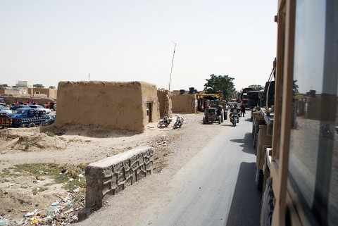 Task Force Iron Soldiers drive through an Afghan village during a recent convoy of vehicles and equipment.  The convoy was the largest resupply the unit has conducted since arriving in February.  Despite encountering five IEDs and being fired upon by insurgents, the mission was a success and no injuries were sustained. (Official U.S. Army Photo)