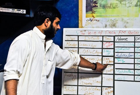 Abdulsalam Omary, “Voice of the Pech” broadcasting manager, goes over the radio station’s schedule with his fellow employees July 19th. The “Voice of the Pech” at 101.1 FM is a popular radio station in Nangalam, Afghanistan, and is heard by thousands of locals in the Pech River Valley. (Photo by U.S. Army Capt. Jonathan J. Springer, 1st Battalion, 327th Infantry Regiment)