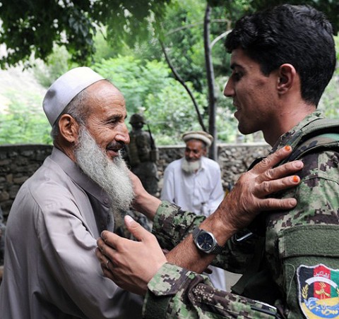 Afghan National Army Lt. Hesamodin, a platoon leader with 2nd Kandak, 2nd Brigade, greets an elder from the village of Shamun in eastern Afghanistan’s Kunar province during a July 14th meeting. (Photo by U.S. Army Staff Sgt. Gary A. Witte, 300th Mobile Public Affairs Detachment)