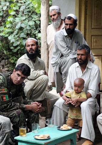 Afghan National Army Lt. Hesamodin, a platoon leader with 2nd Kandak, 2nd Brigade, and residents of the village of Shamun in eastern Afghanistan’s Kunar province listen to discussions during a July 14th meeting. (Photo by U.S. Army Staff Sgt. Gary A. Witte, 300th Mobile Public Affairs Detachment)