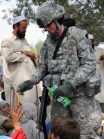 U.S. Army Staff Sgt. Nicole Olcott passes out school supplies to children in an internally displaced persons camp in the Beshood district of eastern Afghanistan’s Nangarhar province Aug. 14th. The two boxes of school supplies came from the Matthew Freeman Foundation, the Adopt-A-Soldier program and Olcott’s own nonprofit organization, Operation New Start. (Photo by U.S. Army Spc. Albert L. Kelley, 300th Mobile Public Affairs Detachment)