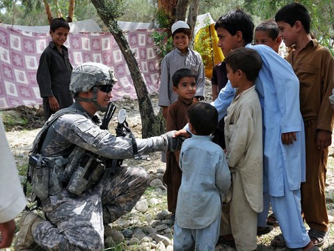 U.S. Army Cpl. Joshua A. Poindexter, of San Diego, a team leader with 2nd Squad, 1st Platoon, 630th Military Police Company, Task Force Spartan, shakes hands withyoung villagers after helping pass out donated school supplies in the Beshood district of Eastern Afghanistan’s Nangarhar province Aug. 14th. (Photo by U.S. Army Spc. Albert L. Kelley, 300th Mobile Public Affairs Detachment)