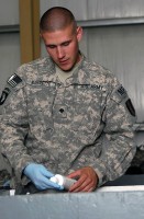 U.S. Army Spc. David Barrette, 342nd Military Police Company customs agent and Worcester, MA, native, inspects the contents of a redeploying Airman’s baggage at the Bagram Airfield’s customs terminal August 2nd. (Photo by U.S. Army Spc. Jay Venturini, 304th Public Affairs Detachment)