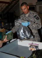 U.S. Army Spc. Martin Pena, 342nd Military Police Company customs agent and New Bedford, MA, native, inspects the contents of a redeploying Airman’s baggage at the Bagram Airfield’s customs terminal August 2nd. (Photo by U.S. Army Spc. Jay Venturini, 304th Public Affairs Detachment) 