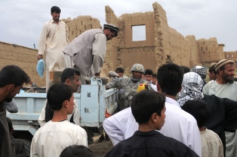 U.S. Army Capt. Terrance McIntosh, a Phoenix native and civil affairs officer from Headquarters, Headquarters Troop, 1st Squadron, 172nd Cavalry Regiment, distributes much needed supplies to the villages of Bashikal in Parwan province during a humanitarian aid mission Aug 25th. Distributing humanitarian aid to these villages is also helping the relations between the local villagers and coalition forces, said McIntosh. (Photo by U.S. Army Pfc. Roy Mercon, Task Force Wolverine Public Affairs, 86th Infantry Brigade Combat Team [Mountain])