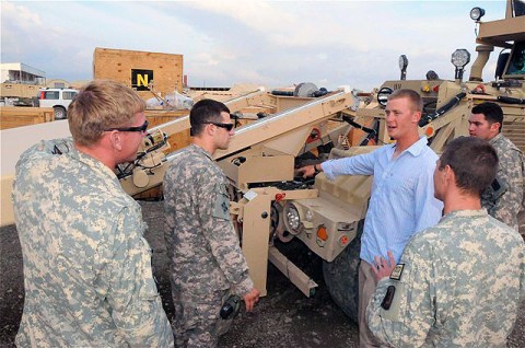 Codey M. Johnson, a native of Eau Claire, WI, and instructor of the Husky-Mounted Detection System Operators Course, describes various parts and functions of a Husky vehicle equipped with new ground penetrating radar panels here Aug. 5th. The panels assist Soldiers in finding improvised explosive devices by providing three-dimensional images of the ground in front of the Husky. (Photo by U.S. Army Sgt. Brent C. Powell, 3rd Brigade, 101st Airborne Division)