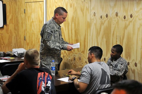 U.S. Army 1st Sgt. Ronald Wright of Granville, OH hands out a test to U.S. Army Pfc. Ricardo Hernandez of Strasburg, CO, Headquarters and Headquarters Company, Task Force Bastogne, in a criminal justice class offered at Forward Operating Base Fenty here August 10th. (Photo by U.S. Army Spc. Richard Daniels Jr., Task Force Bastogne Public Affairs)