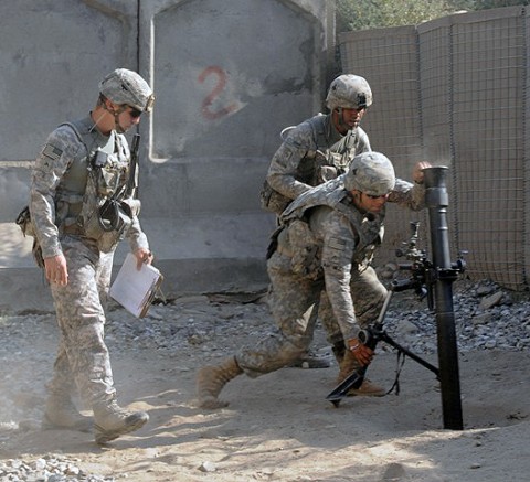 At left, U.S. Army Cpl. Billy Rose of Saginaw, MI, Task Force Bulldog, supervises as Soldiers adjust the still-smoking mortar during a fire mission to protect Combat Outpost Michigan here as it comes under enemy attack July 11th. (Photo by U.S. Army Staff Sgt. Gary A. Witte, 300th Mobile Public Affairs Detachment)