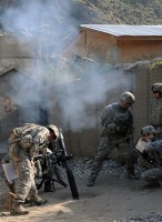 At left, U.S. Army Cpl. Billy Rose of Saginaw, MI, Task Force Bulldog, supervises as Soldiers adjust the still-smoking mortar during a fire mission to protect Combat Outpost Michigan here as it comes under enemy attack July 11th. (Photo by U.S. Army Staff Sgt. Gary A. Witte, 300th Mobile Public Affairs Detachment)