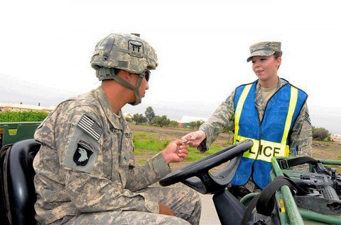 U.S. Air Force Staff Sgt. Amber R. Perez (right), a native of Vancouver, WA, and a security forces patrolman with the 655th Air Expeditionary Squadron, gives an identification card back to a Task Force Rakkasan Soldier on Camp Salerno during a recent vehicle safety enforcement  checkpoint.  (Photo by U.S. Army Sgt. Brent C. Powell, 3rd Brigade, 101st Airborne Division)