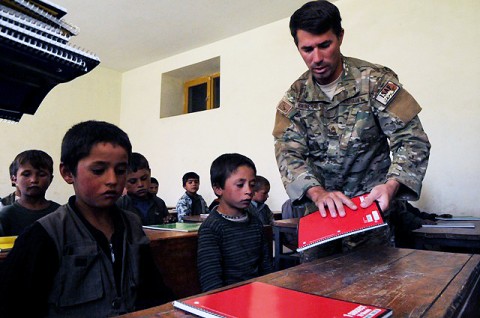 U.S. Army Master Sgt. Chad Rhinehart of Washington, NJ, Panjshir Provincial Reconstruction Team’s civil affairs noncommisioned officer in charge, hands out notebooks to students who attend the Kur Petab boys middle school in Khenj District here Aug. 23rd. (Photo by U.S. Air Force Tech. Sgt. Sean M. White, Panjshir Provincial Reconstruction Team)  