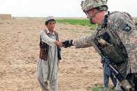 U.S. Army 1st Lt. Vance Gonzales, a native of Weddinton, NC, and executive officer, Company A, 3rd Battalion, 187th Infantry Regiment, 101st Airborne Division out of Fort Campbell, KY, takes a moment to shake hands with a young Afghan boy from the Sardar Kala Village of the Andar District in Ghazni Province August 6th. (Photo by U.S. Army Spc. Lorenzo D. Ware, 982nd Combat Camera Company)