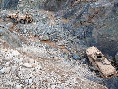 A vehicle recovery crew from Company B, 626th Brigade Support Battalion, 3rd Brigade, 101st Airborne Division adjusts the cabling and ropes connecting their wrecker to a mine-resistant, ambush-protected vehicle that had rolled off a steep mountain pass and lodged against a rock formation approximately 50-feet below. The recovery took the team four-days.  (Photo courtesy of the U.S. Army)