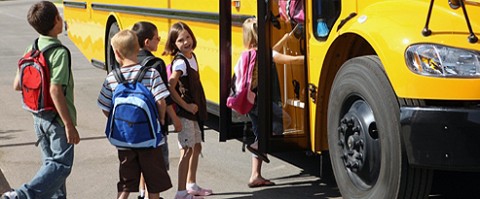 School Kids getting on a bus.