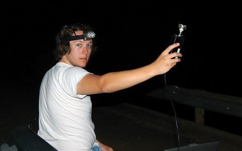 Austin Peay State University graduate student Seth McCormick listens for bats at a stationary observation point within the Land Between The Lakes Recreational Area. (Photo By Andy Barrass)