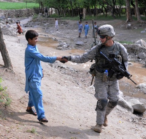 Kunar Province, Afghanistan, Afghanistan - U.S. Army Spc. Cory B. Petrosky of Grapevine, Texas, a radio operator with 1st Platoon, Company A, 1st Battalion, 327th Infantry Regiment, Task Force Bulldog, greets a youth outside the village of Shamir Kowt in eastern Afghanistan's Kunar province July 21. The unit, based at nearby Combat Outpost Honaker-Miracle, patrolled the area with Afghan National Police officers and surveyed business owners in the village bazaar about their concerns. (Photo by U.S. Army Staff Sgt. Gary A. Witte, 300th Mobile Public Affairs Detachment)