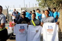 Two Soldiers and a Sailor show the commemorative T-shirt they each received at the completion of Bagram Airfield’s Women’s Equality Day five-kilometer run Aug. 26th. (Photo by U.S. Army Pfc. Roy Mercon, Task Force Wolverine Public Affairs)