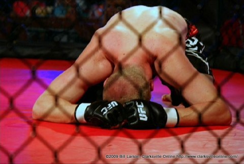 A cage match fighter in the agony of defeat