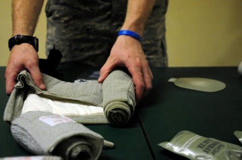 U.S. Air Force Senior Airman Jeffrey Marr from Ramstein Air Base, Germany, a Laghman Provincial Reconstruction Team medic, rolls up an abdominal dressing after conducting a combat lifesaver refresher course here Aug. 12th. (Photo by U.S. Air Force Staff Sgt. Ave I. Pele, Laghman Provincial Reconstruction Team Public Affairs)