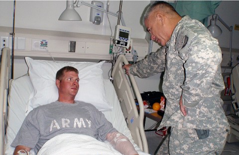 U.S. Army Maj. Gen. John Campbell, Commander of the 101st Airborne Division, stands over the bedside of U.S. Army Sgt. William Bickers Sept. 16th at Bagram Air Field in Afghanistan. Campbell presented Bickers with the Combat Infantryman’s Badge for his direct engagement with the enemy and a Purple Heart for being wounded in the line of duty while on a foot patrol in Andar District, Ghazni province. (U.S. Army photo by 1st Lt. R.J. Peek) U.S. Army Maj. Gen. John Campbell, Commander of the 101st Airborne Division, stands over the bedside of U.S. Army Sgt. William Bickers Sept. 16th at Bagram Air Field in Afghanistan. Campbell presented Bickers with the Combat Infantryman’s Badge for his direct engagement with the enemy and a Purple Heart for being wounded in the line of duty while on a foot patrol in Andar District, Ghazni province. (U.S. Army photo by 1st Lt. R.J. Peek)