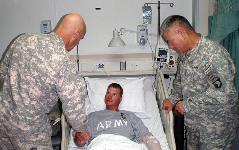 U.S. Army Sgt.William Bickers shakes hands with Command Sgt. Maj. Scott Schroeder,the command sergeant major for Combined Joint Task Force 101, Sept. 16th at Bagram Air Field in Afghanistan. Maj. Gen. John Campbell, Commander of the 101st Airborne Division, awarded Bickers with the Combat Infantryman’s Badge for his direct engagement with the enemy and a Purple Heart for being wounded in the line of duty while on a foot patrol in Andar District, Ghazni province. (U.S. Army photo by 1st Lt. R.J. Peek)