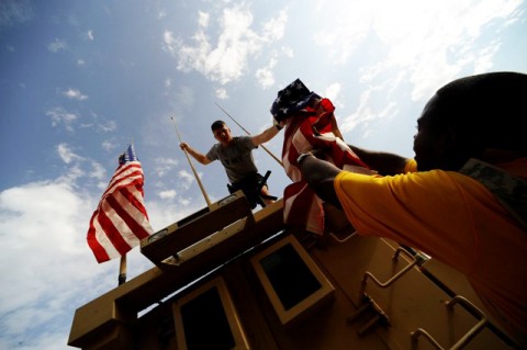 U.S. Army Cpl. Jerome Halaszynski from McKeesport, Pa., and U.S. Navy Petty Officer 1st Class Gerald Rawlins from Indianapolis, both members of the Khowst Provincial Reconstruction Team, take down American flags here Sept. 11. (Photo by U.S. Air Force Senior Airman Julianne M. Showalter, Khowst Provincial Reconstruction Team Public Affairs Office)