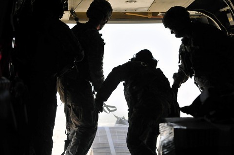 The jumpmaster waits for the Chinook pilots to give the order to “execute” the airdrop before pushing the bundle out the back of the aircraft. The Chinooks are equipped with “Helicopter Internal Cargo Handling Systems”, rollers, which allows for less force when dropping a bundle weighing over 200 pounds. 