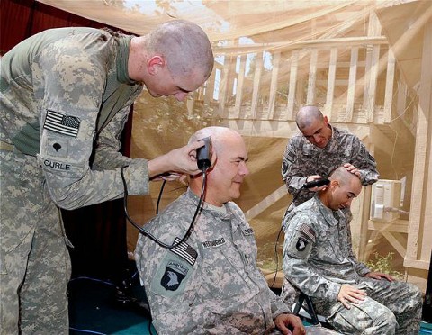 Soldiers from Task Force Red Knight’s 3rd Battalion, 320th Field Artillery Regiment shave each other’s heads in a show of support for two of the regiment’s family members who have been diagnosed with cancer. Approximately 20 Soldiers participated in the event Sep. 4 at the regiment’s headquarters on Forward Operating Base Salerno here. (Photo by U.S. Army Sgt. Brent C. Powell, 3rd Brigade, 101st Airborne Division)