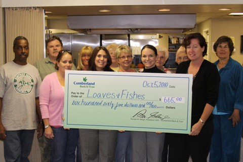 Cumberland Bank & Trust employees Dawn Burr and Emily Clouser present Susan Chapman, Executive Director of Loaves and Fishes and volunteers with a donation from Cumberland Bank & Trust. (Charlie Koon)