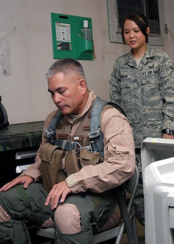 U.S. Air Force Airman 1st Class Angela L. Morrow, 336th Expeditionary Fighter Squadron aircrew flight equipment technician from Seneca, Mo., has U.S. Army Maj. Gen. John F. Campbell, lean forward to check the fit of a G suit, survival vest and parachute harness here Oct. 20th. (Photo by U.S. Air Force Tech. Sgt. M. Erick Reynolds, Regional Command East Public Affairs)