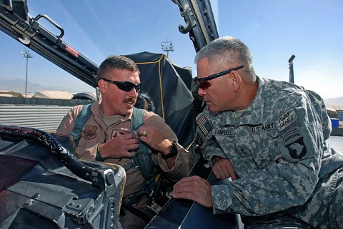 U.S. Air Force Capt. Ross E. Clark, 336th Expeditionary Fighter Squadron F-15 weapons systems officer, demonstrates to U.S. Army Maj. Gen. John F. Campbell, Combined Joint Task Force 101, Regional Command East commander, the proper attachment of the parachute harness to the ejection system of the F-15E Strike Eagle Oct 20. (Photo by U.S. Air Force Tech. Sgt. M. Erick Reynolds, Regional Command East Public Affairs)